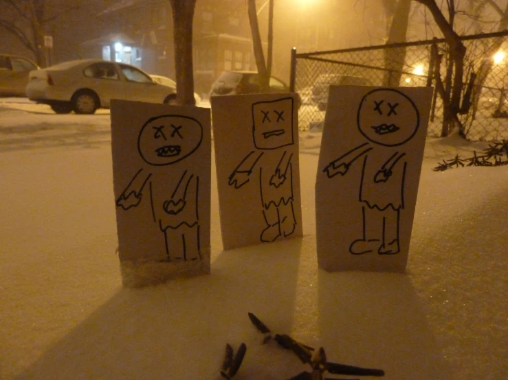 two handmade signs sitting on top of a snow covered surface