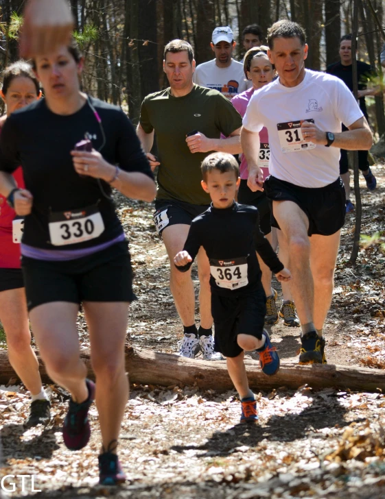 a group of people running on the forest trail