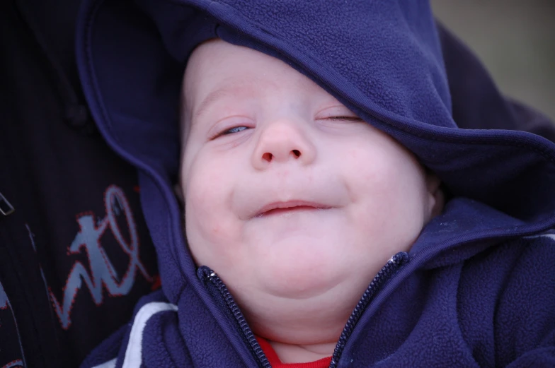 a close up of a child with a blue hoodie on