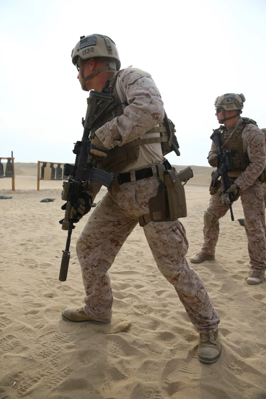 military men running with guns on a desert