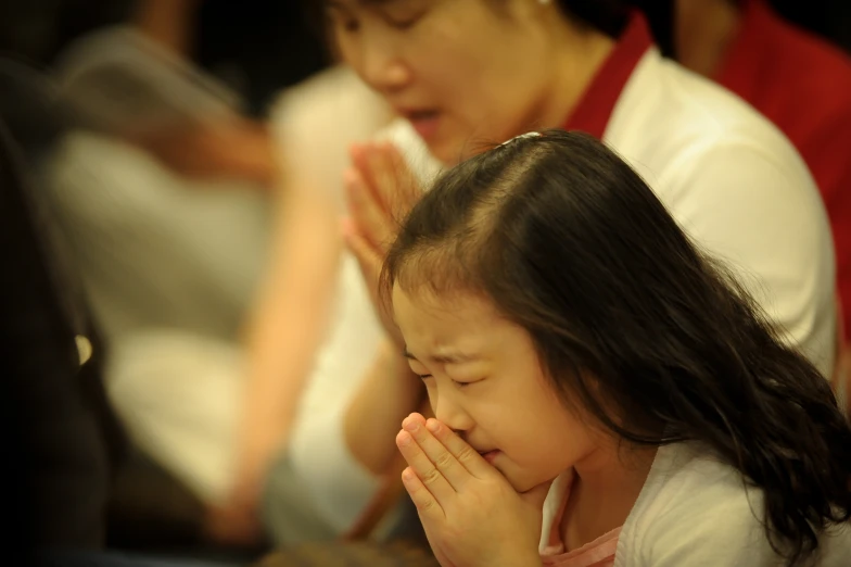 a  in a white shirt holding her hands together