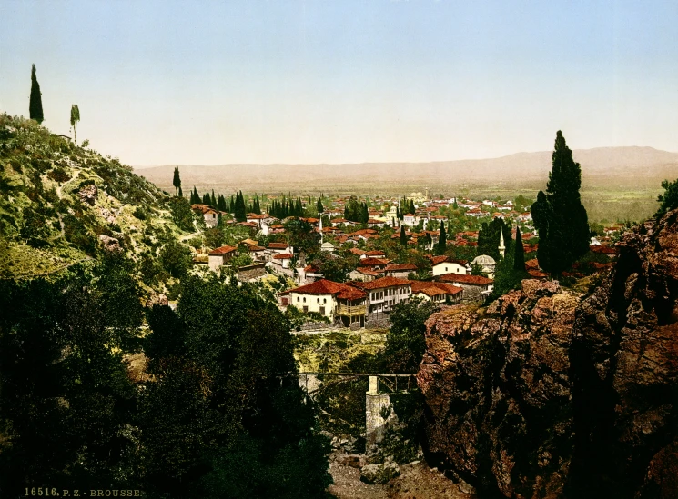 a large town with hills and trees in the background