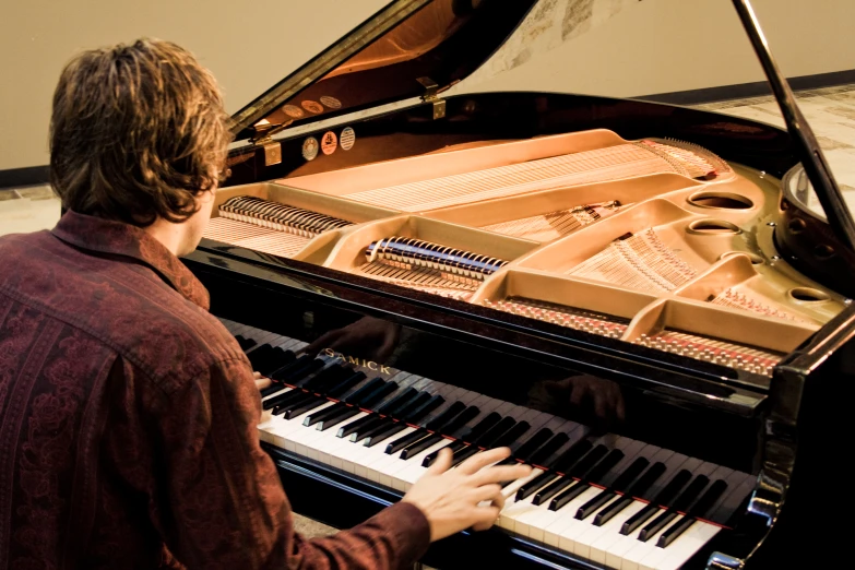 a man that is sitting in front of a piano