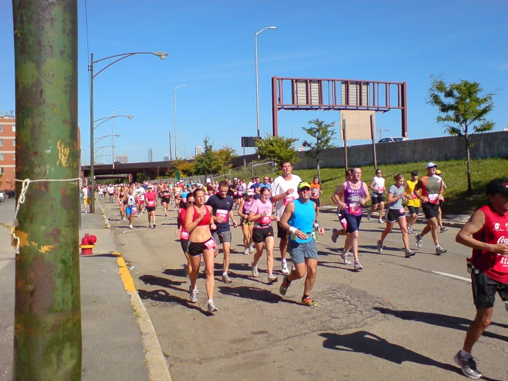 the group of people are running together down the street