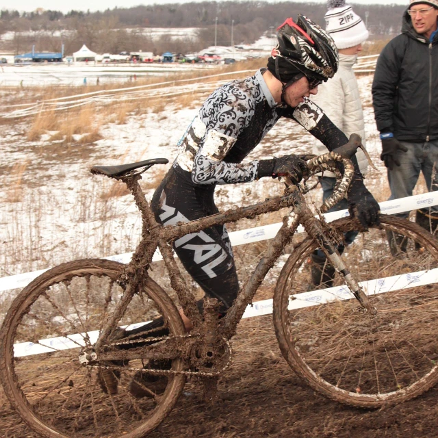 man wearing gear riding on a bicycle down a field