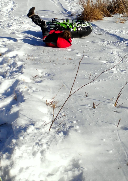 a person lying on the snow with their feet on a snowboard