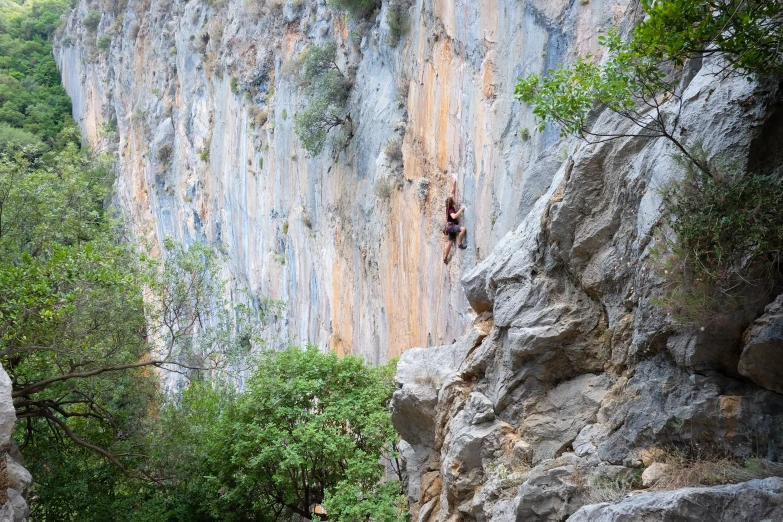 someone climbing up a hill near the water