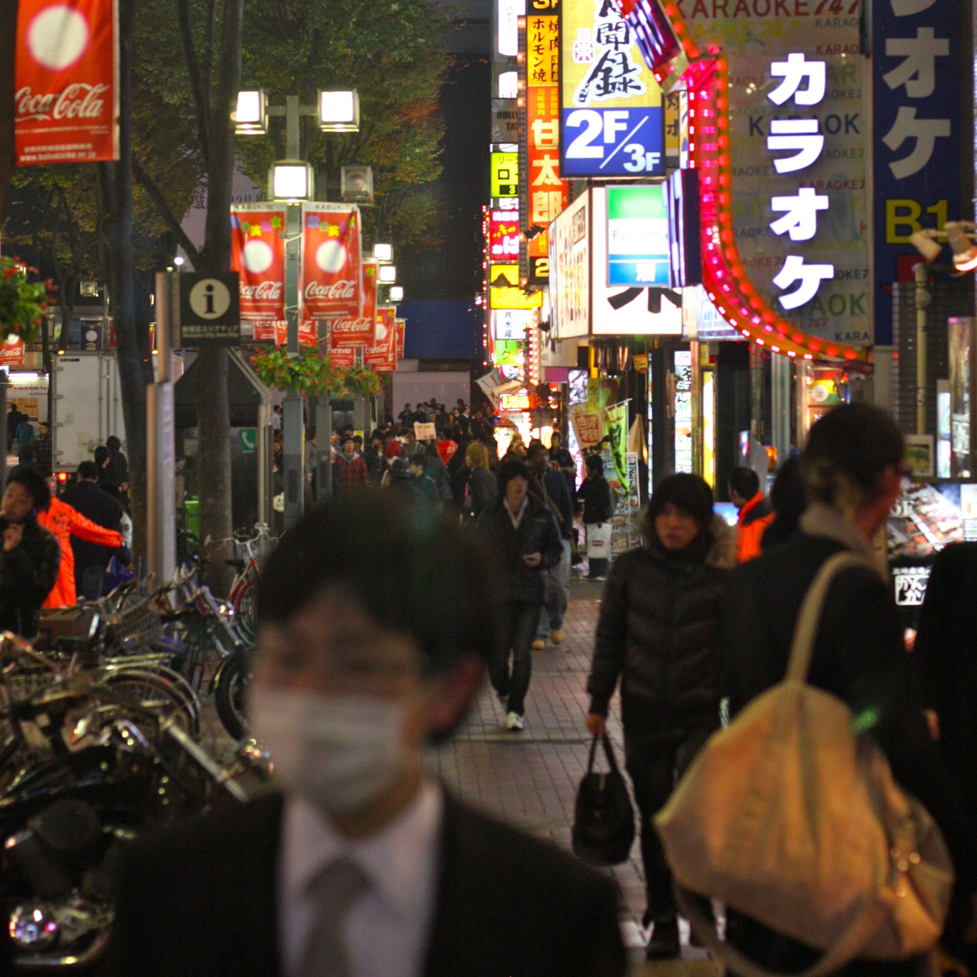 a very busy sidewalk in tokyo with lots of signs