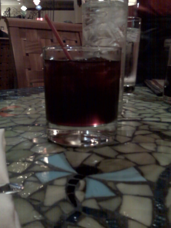 a glass filled with wine and ice sits on the counter