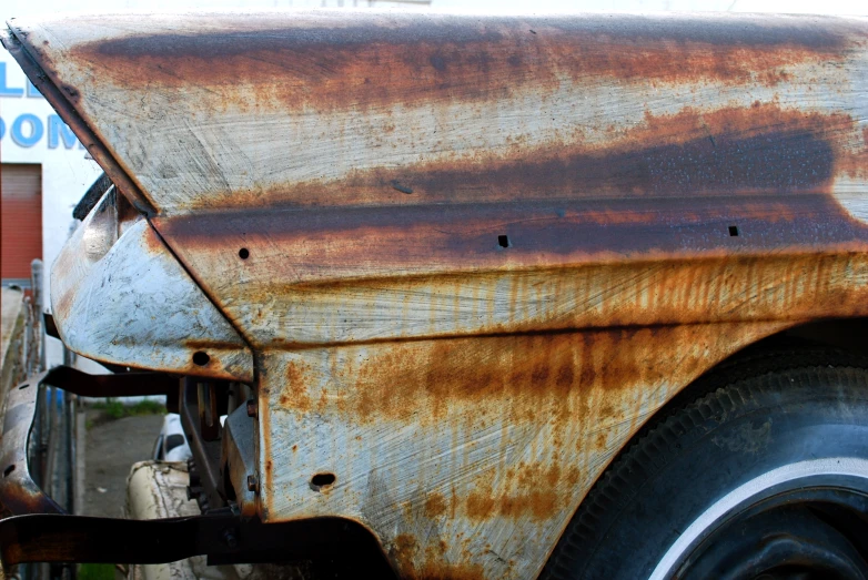 rusted, old truck sitting in front of a small store
