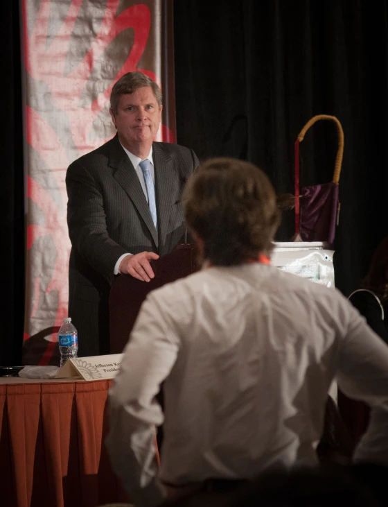 two men sitting at a table talking to each other