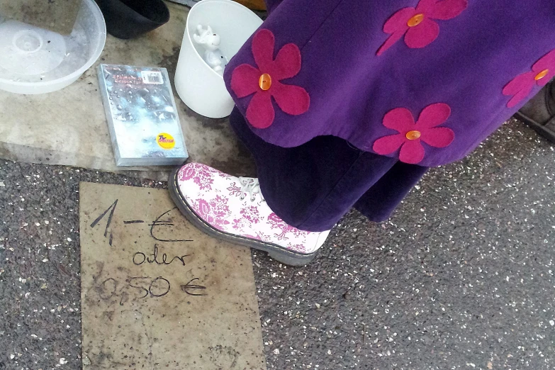 a person standing next to a wall with graffiti written on the pavement