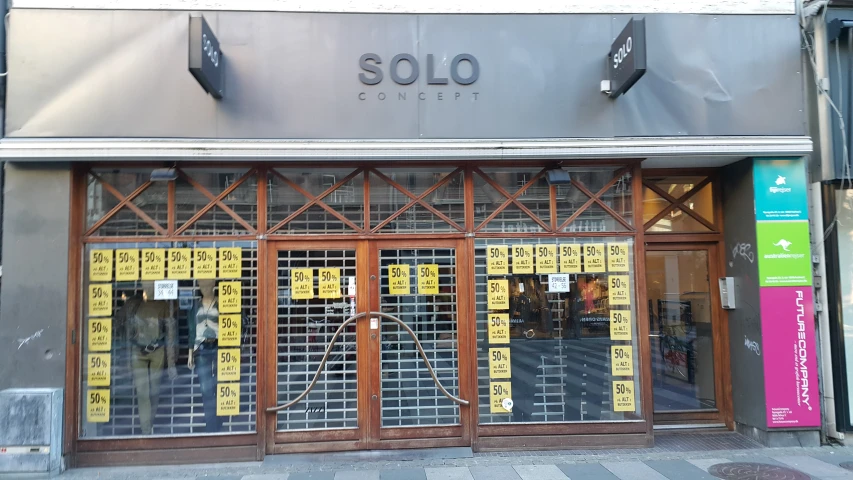 the front of an old fashioned store with yellow posters