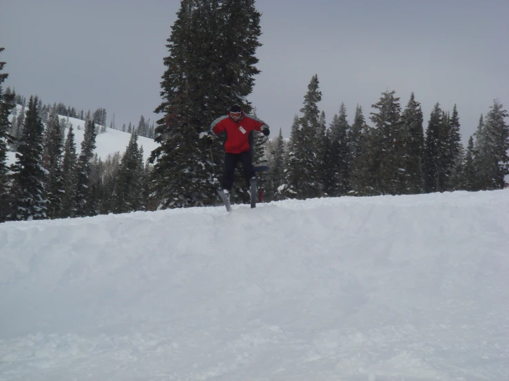 a man riding skis down the side of a snow covered slope