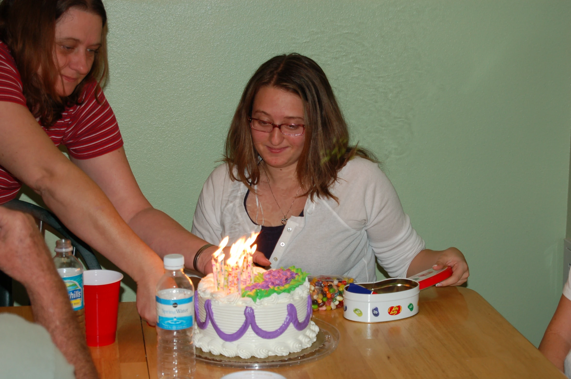 a young woman blows out the candles on her cake