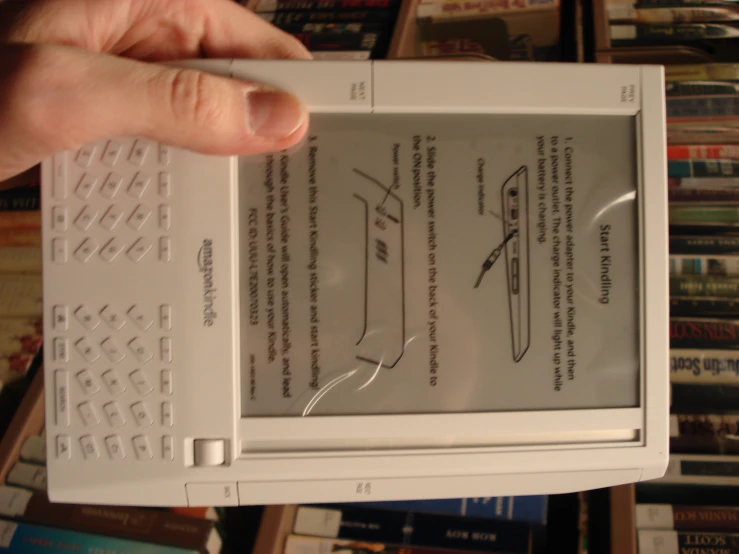 there is a kindle book being held up in front of many books