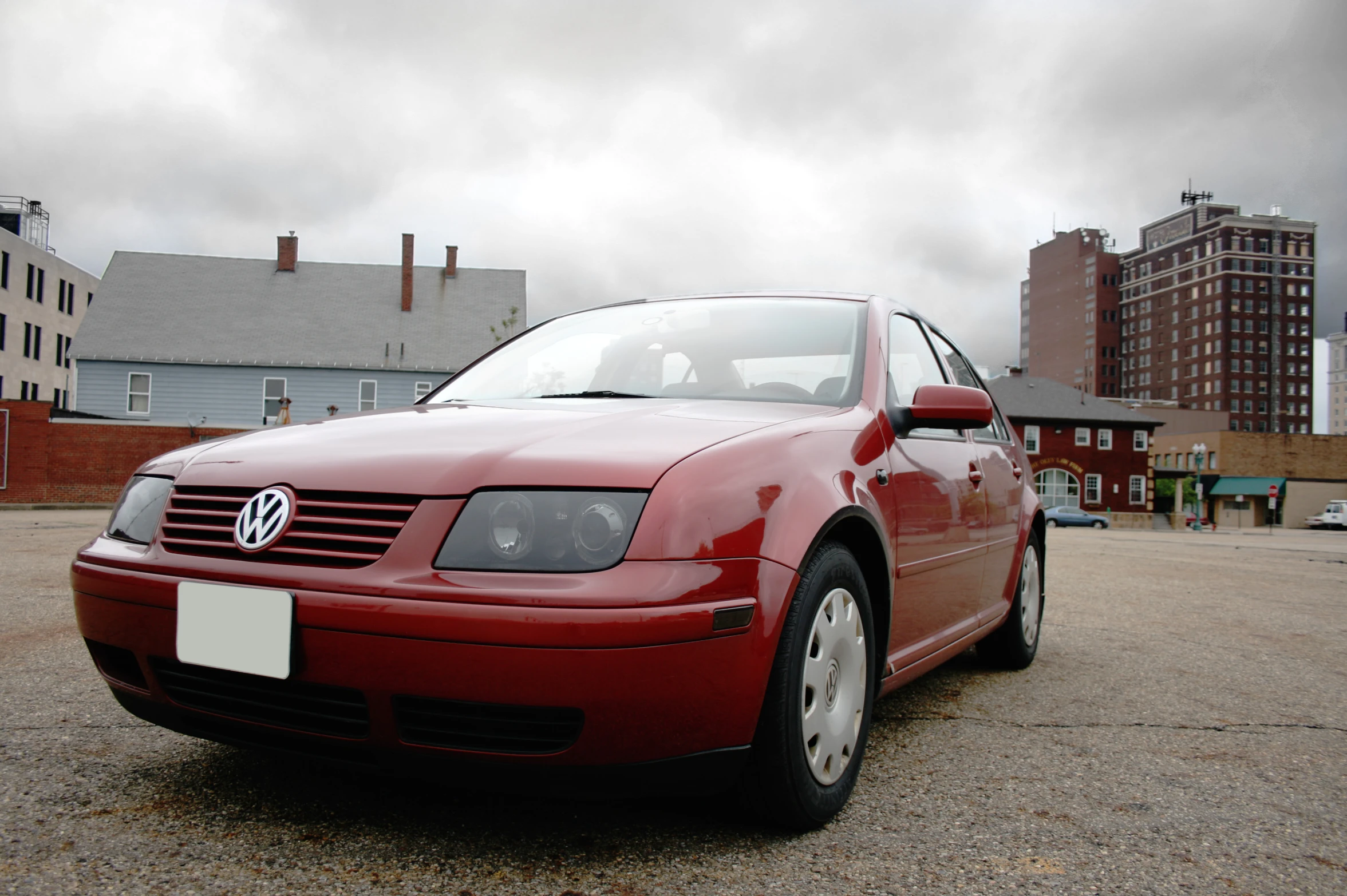 a red car parked next to some buildings