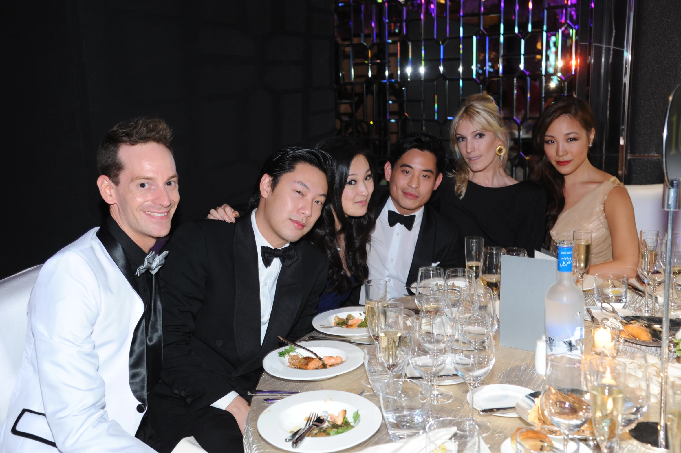 a group of people are sitting at a dinner table