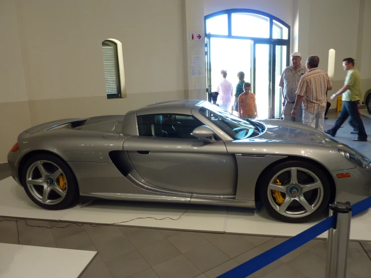 a gray sports car parked inside of a building