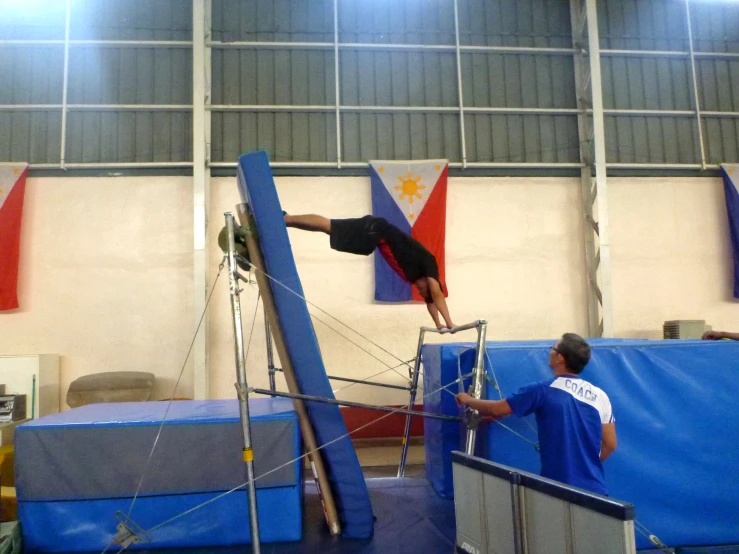 a man doing an acrobatic trick on a trampoline