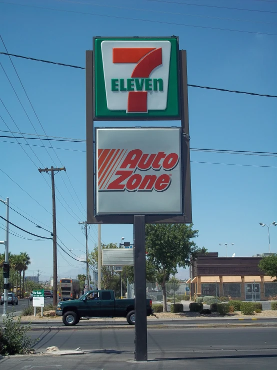 a 7 eleven sign sits in the middle of a street