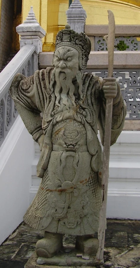 an ancient statue stands near a set of stairs