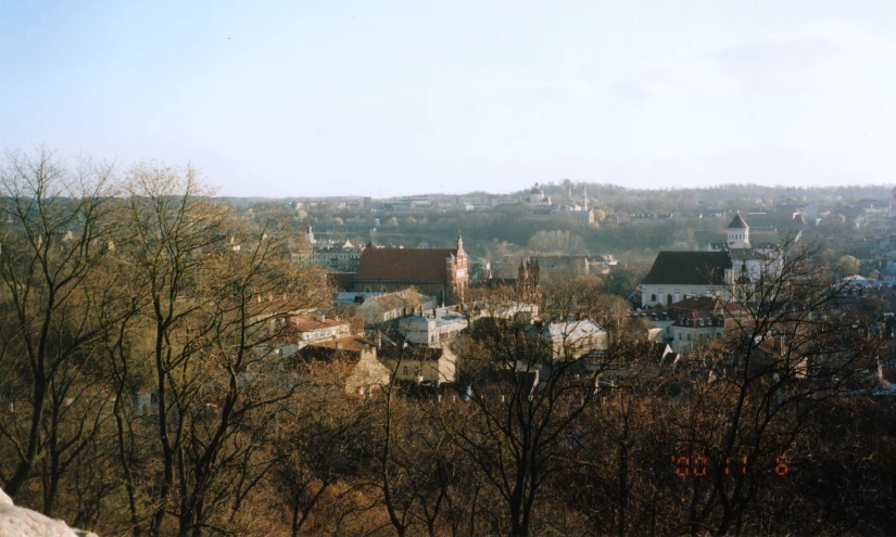 a city with lots of trees in front of a mountain range