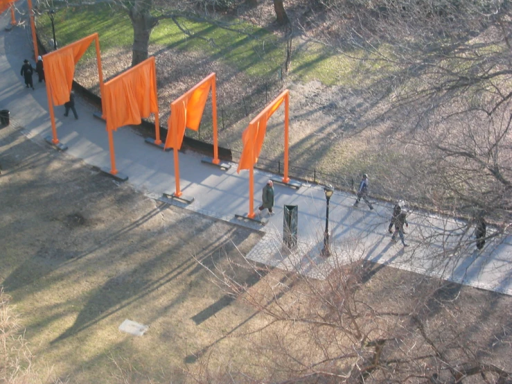 an outdoor space with orange flags and three people on bicycles