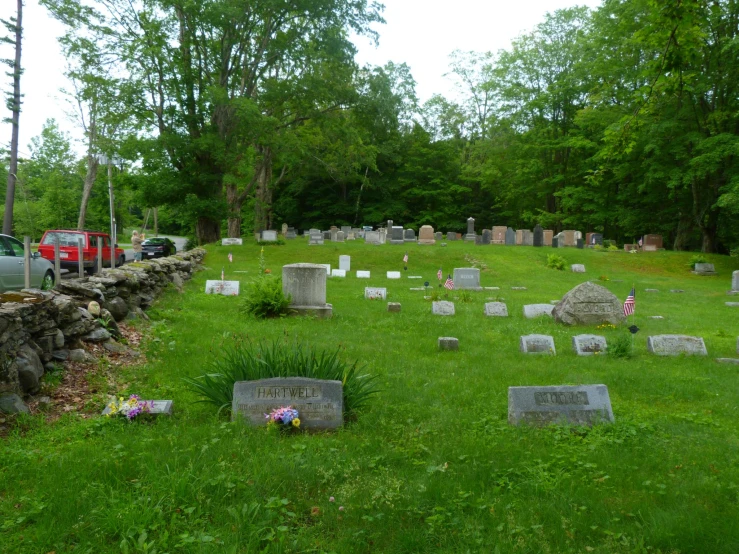 several headstones on the green grass in an cemetery