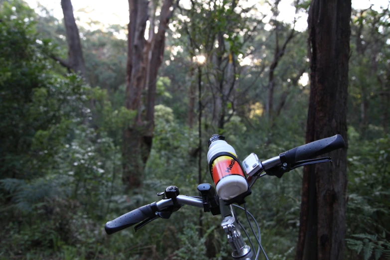 there are two water bottles placed on the handle bar of the bike