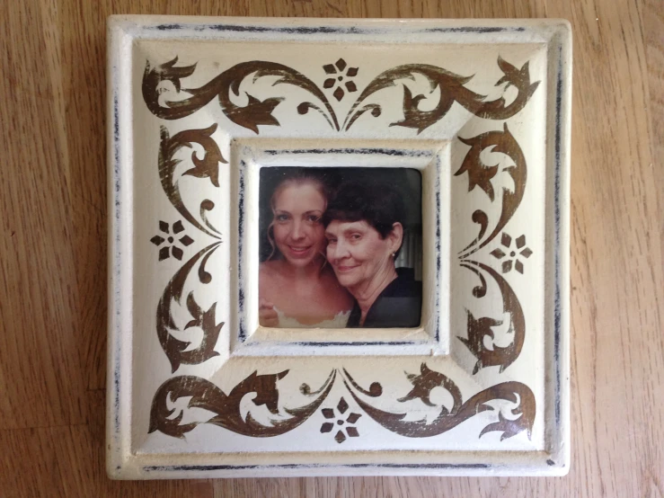 a picture frame with an old po and brown flowers on it