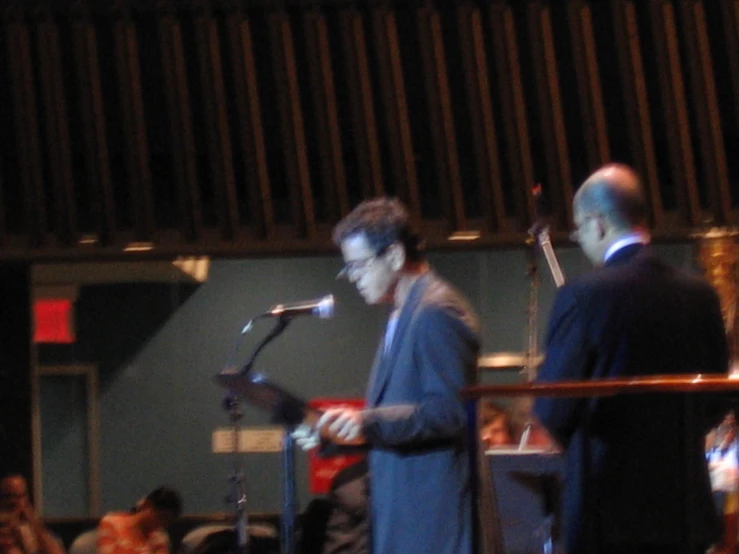 two men in front of microphones at an event