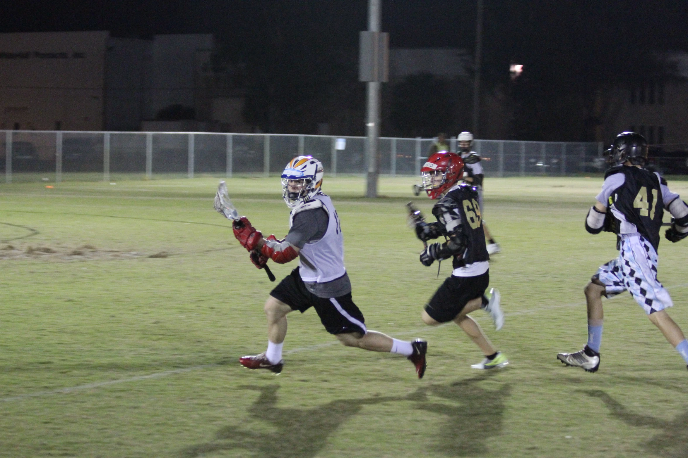 the men are playing lacrosse on the field