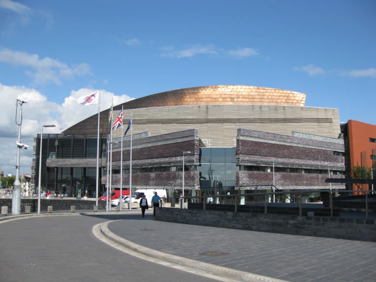 a round building with a blue sky and some flags