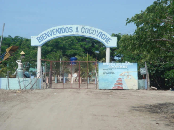 an entrance to the beach with a sign above it