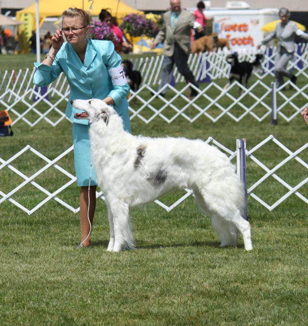 a woman holding an umbrella while petting a dog