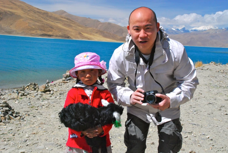 a man holding a stuffed bear with a little girl