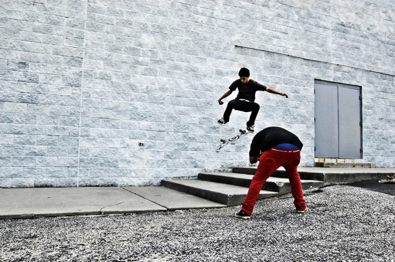 a skateboarder does a trick in front of some steps