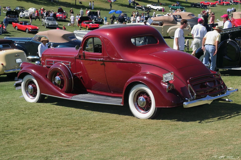 the classic cars are lined up on the grass