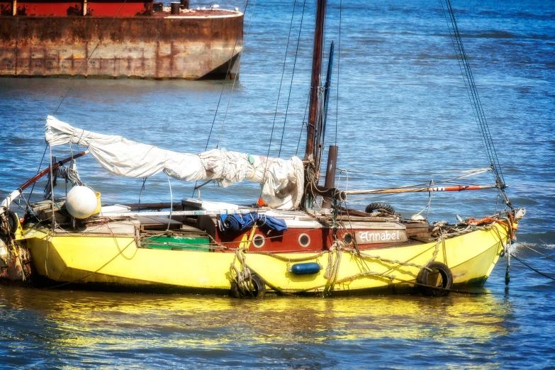 a sailboat sitting on the beach near water