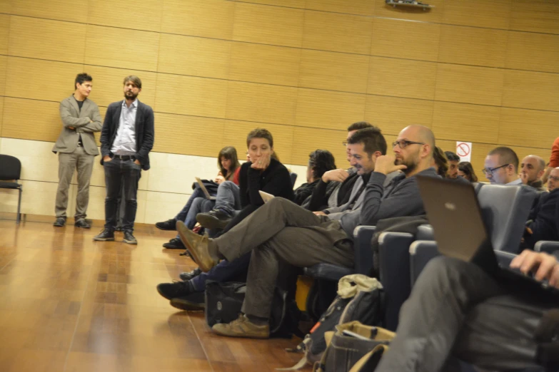 people sitting on chairs in a room next to each other