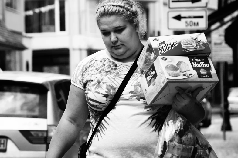 a pregnant woman holding a box of food in the city