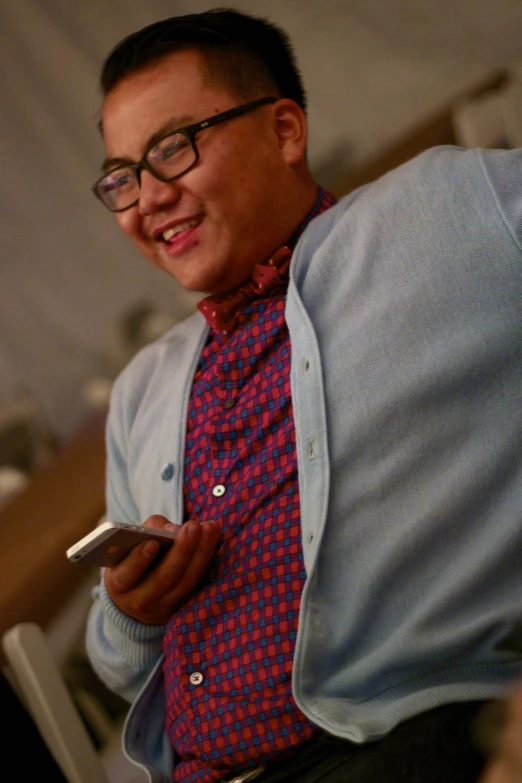 a man standing next to a white chair wearing glasses