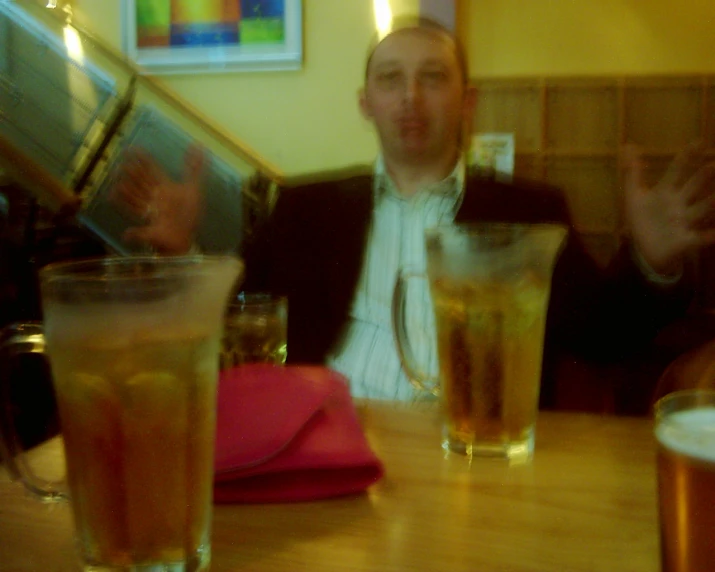 a man sits at a table with many drinks