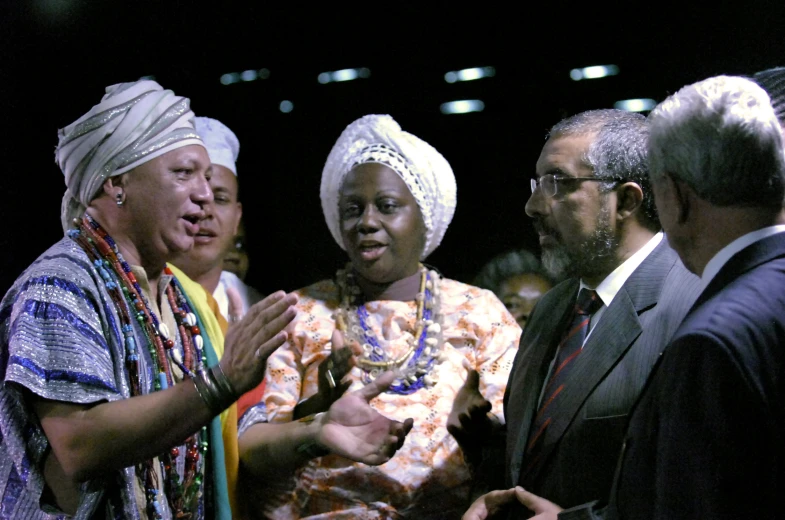 a woman standing next to two men wearing turbans