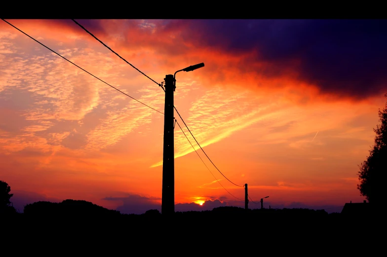 the sun is setting over power lines
