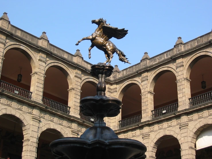 a golden statue standing in front of a building