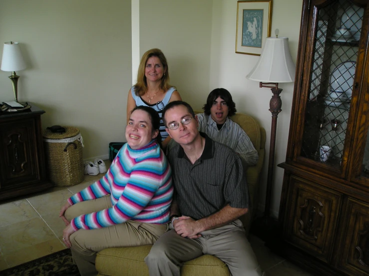 three people posing for a pograph in a living room