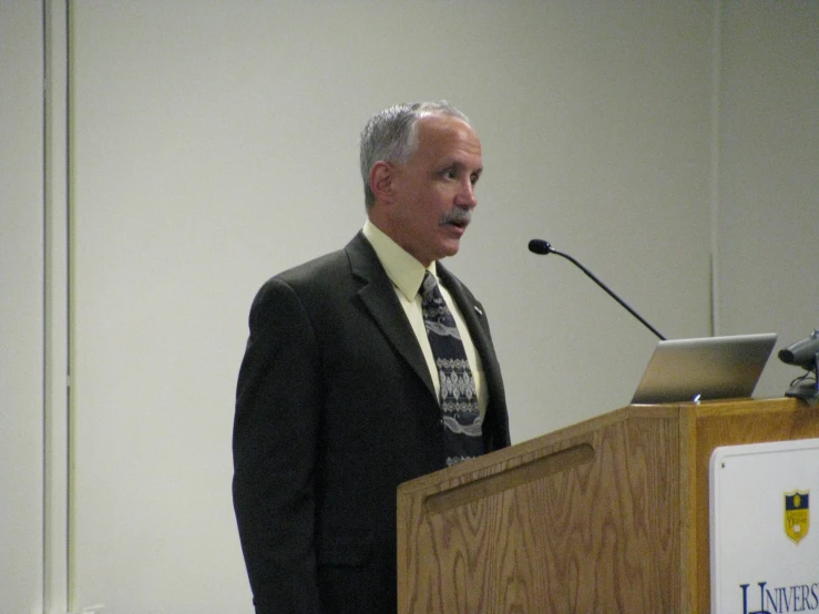 a man wearing a tie in front of a podium