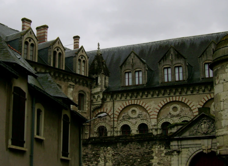 an old stone building has two clock towers on its roof